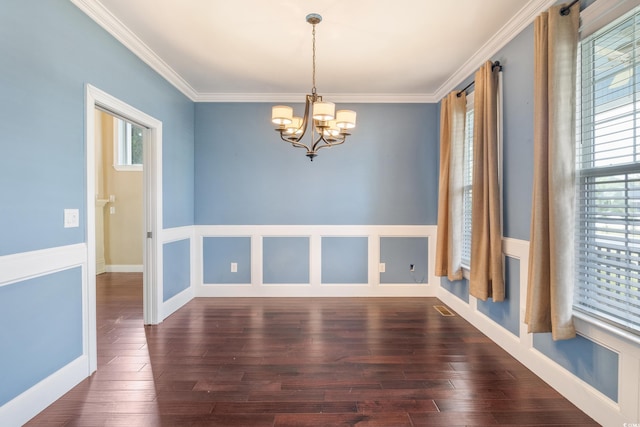 spare room featuring dark wood-style floors, visible vents, a chandelier, and ornamental molding