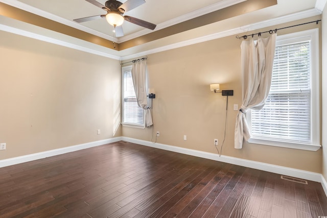 unfurnished room with dark wood-style floors, crown molding, a raised ceiling, visible vents, and baseboards