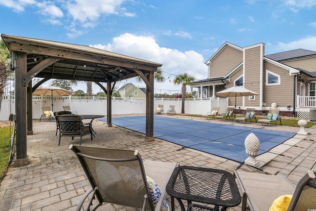 view of pool featuring a patio area, fence, a fenced in pool, and a gazebo