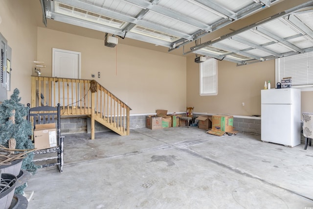 garage featuring a garage door opener and freestanding refrigerator