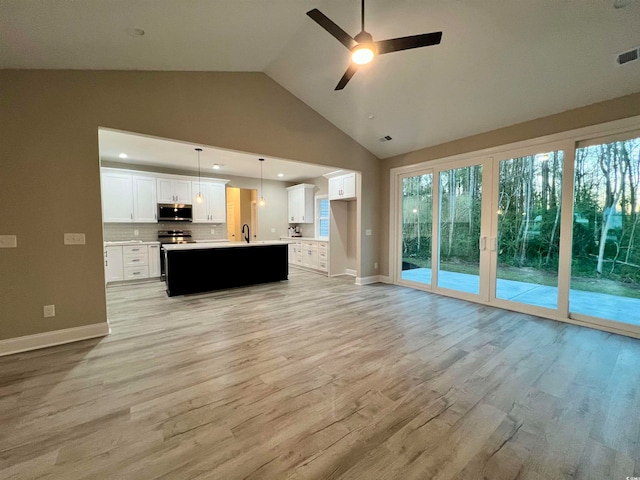 unfurnished living room featuring ceiling fan, sink, high vaulted ceiling, and light hardwood / wood-style flooring