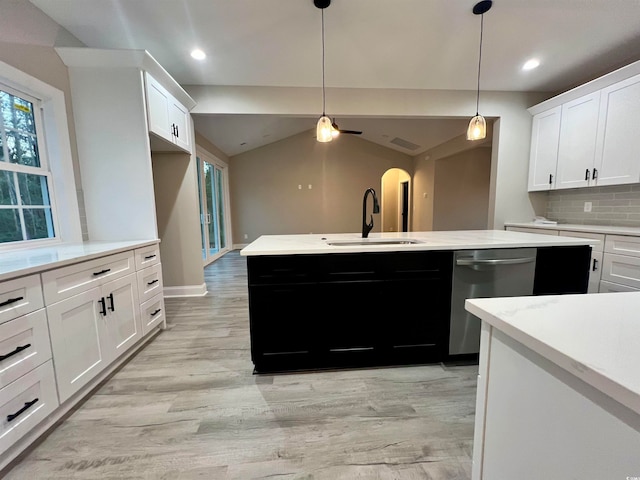 kitchen featuring white cabinets, tasteful backsplash, sink, dishwasher, and lofted ceiling