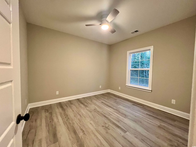 spare room with ceiling fan and wood-type flooring