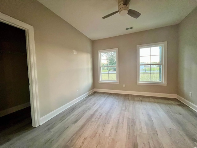 unfurnished room with ceiling fan, vaulted ceiling, and light hardwood / wood-style flooring