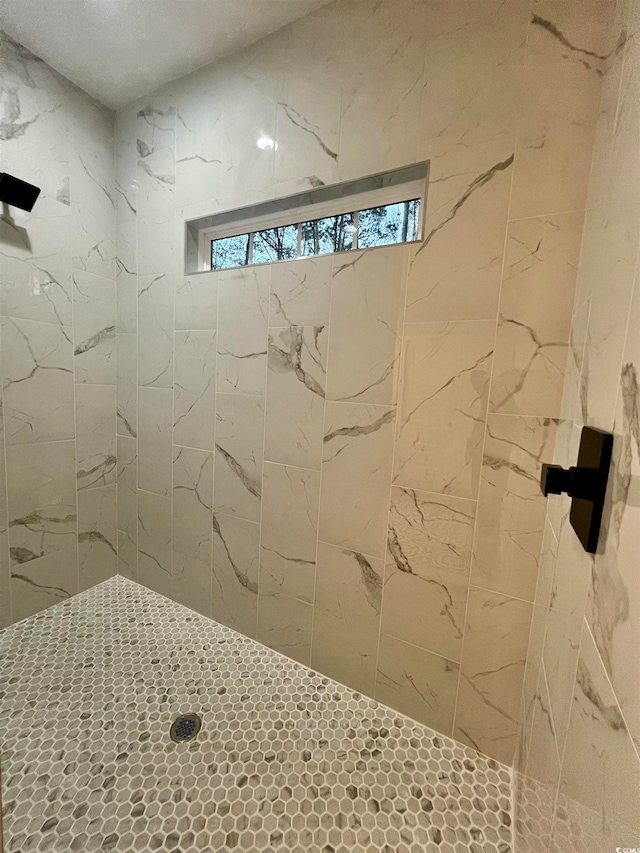 bathroom featuring a tile shower and a wealth of natural light