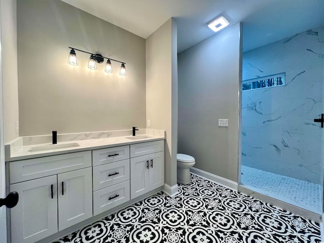 bathroom featuring tile patterned floors, vanity, toilet, and a tile shower