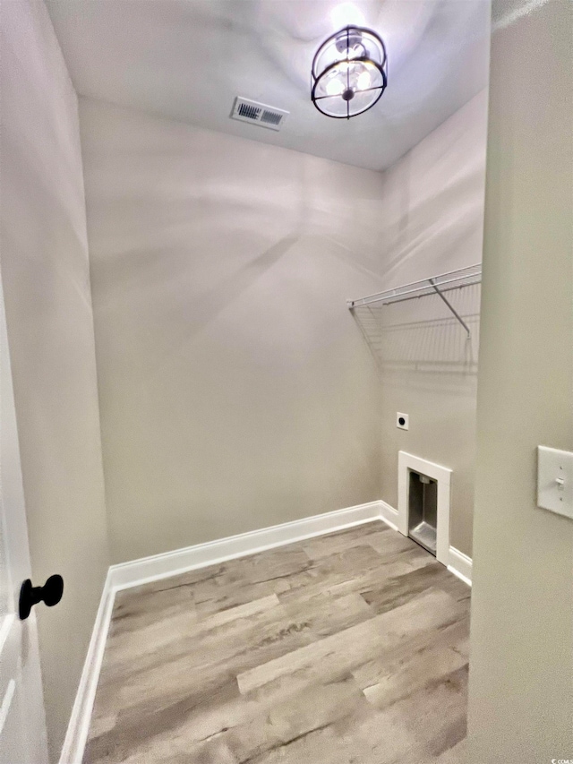 washroom with hardwood / wood-style flooring and hookup for an electric dryer