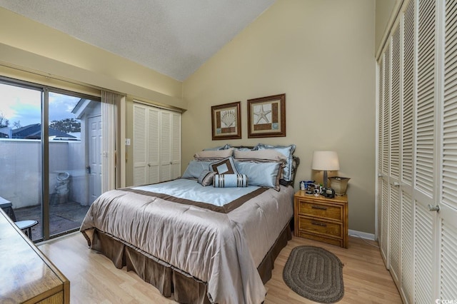 bedroom with a textured ceiling, lofted ceiling, access to outside, a closet, and light wood-type flooring