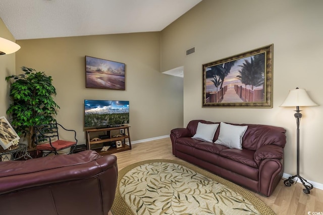 living room with light hardwood / wood-style flooring and vaulted ceiling