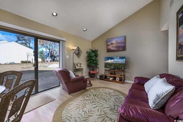 living room featuring light hardwood / wood-style floors and high vaulted ceiling