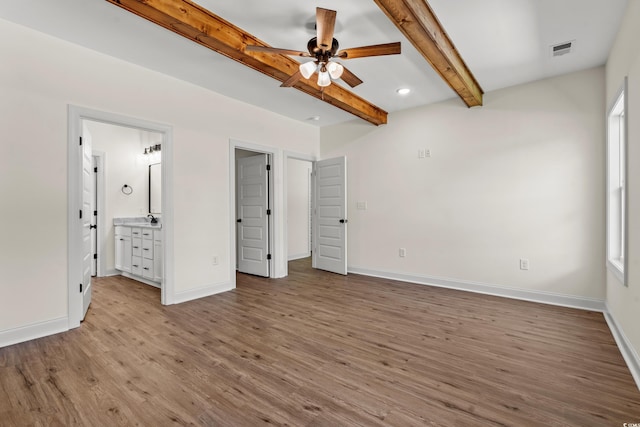 unfurnished bedroom with ensuite bathroom, sink, ceiling fan, light hardwood / wood-style floors, and beam ceiling