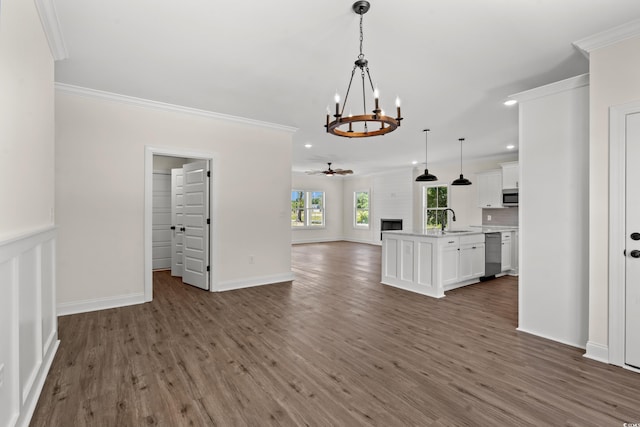 unfurnished living room with crown molding, a fireplace, ceiling fan with notable chandelier, and dark hardwood / wood-style floors