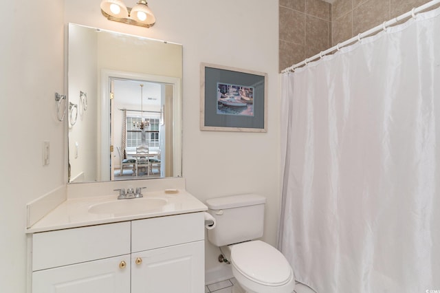 bathroom featuring tile patterned floors, vanity, toilet, and walk in shower