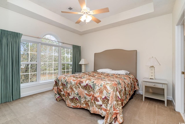 bedroom featuring a tray ceiling, ceiling fan, and carpet flooring