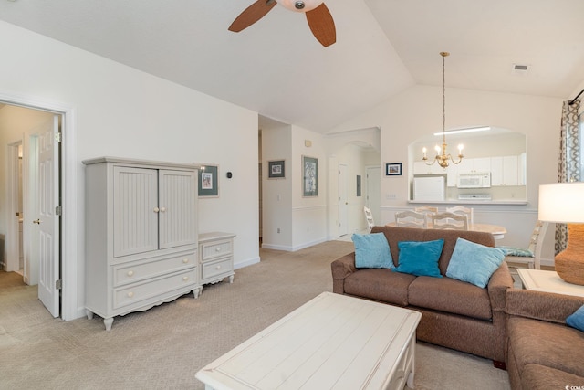 carpeted living room featuring ceiling fan with notable chandelier and lofted ceiling