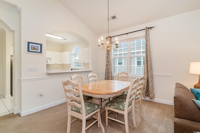 dining space featuring vaulted ceiling, light colored carpet, an inviting chandelier, and a wealth of natural light