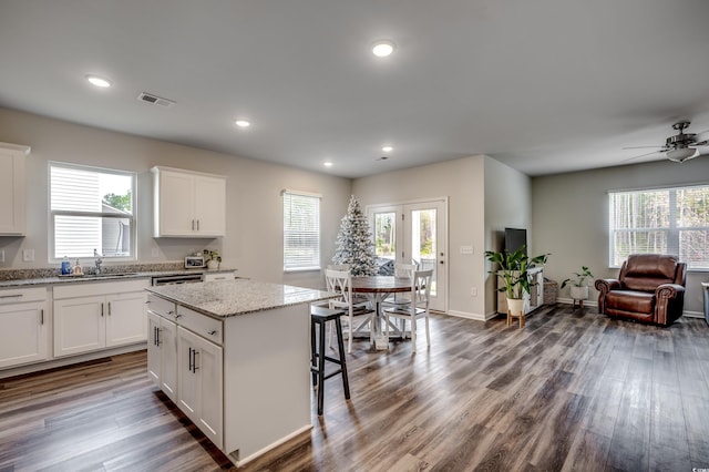 kitchen featuring a kitchen island, white cabinetry, and a wealth of natural light