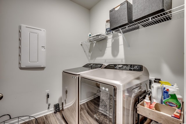 laundry room featuring hardwood / wood-style flooring, washing machine and dryer, and electric panel