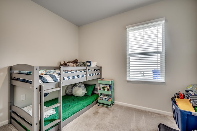 bedroom with light colored carpet and multiple windows