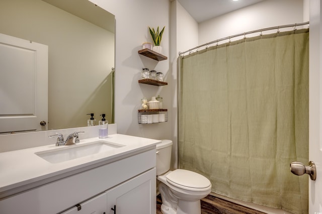 bathroom with walk in shower, toilet, vanity, and hardwood / wood-style flooring