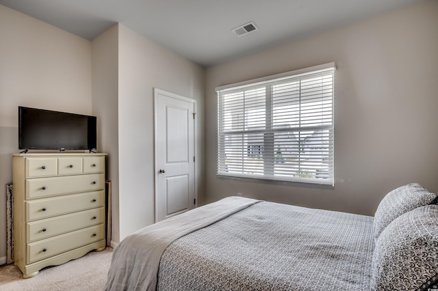 bedroom with multiple windows and light colored carpet