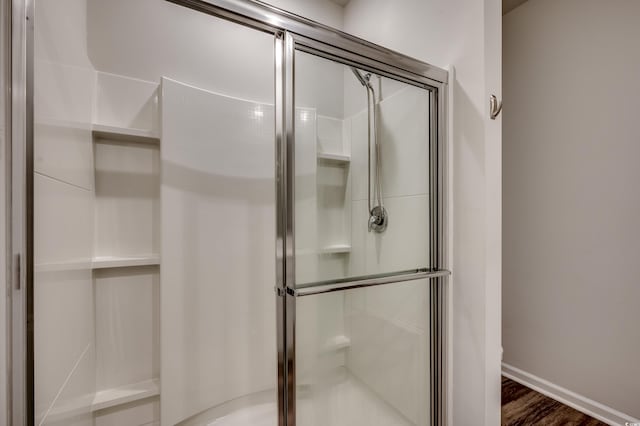 bathroom featuring hardwood / wood-style floors and a shower with door