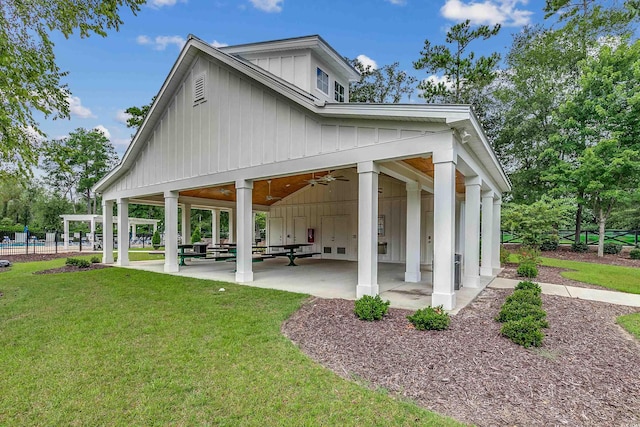 rear view of property featuring ceiling fan, a patio area, and a yard