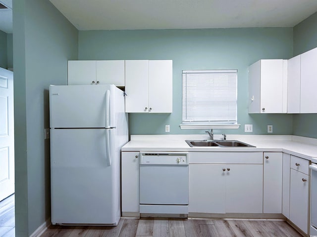 kitchen with white cabinetry, sink, light hardwood / wood-style floors, and white appliances