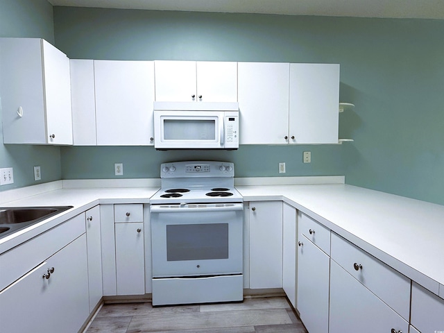 kitchen with white cabinetry, light wood-type flooring, white appliances, and sink