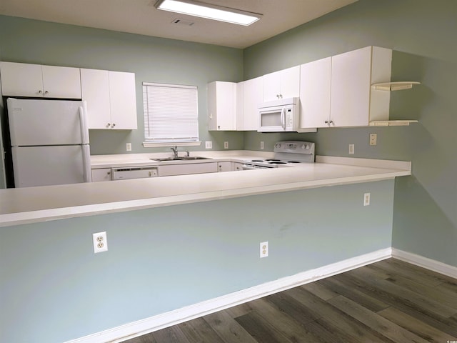 kitchen with kitchen peninsula, white appliances, dark wood-type flooring, sink, and white cabinets