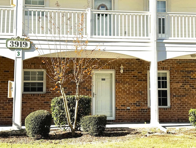 view of exterior entry featuring a balcony