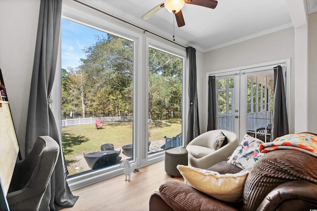 interior space with access to exterior, french doors, light wood-type flooring, ceiling fan, and crown molding