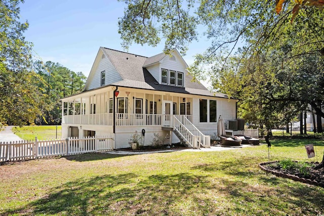 view of front of property featuring a porch, a front lawn, and central air condition unit