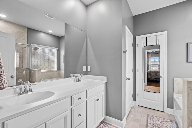 bathroom featuring plus walk in shower, vanity, and tile patterned floors