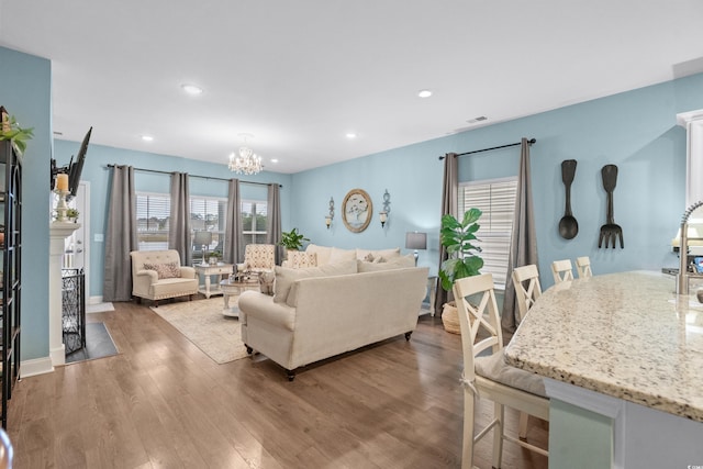 living room featuring a notable chandelier and light wood-type flooring