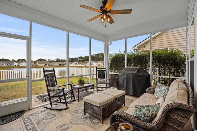 sunroom with ceiling fan, a healthy amount of sunlight, and wooden ceiling