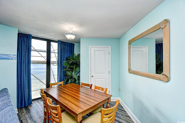 dining area featuring hardwood / wood-style flooring and a textured ceiling