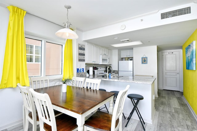 dining space with sink and light hardwood / wood-style floors