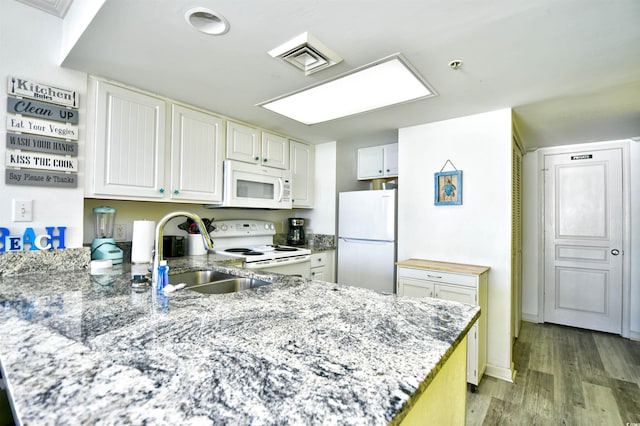 kitchen featuring white appliances, sink, light wood-type flooring, white cabinetry, and kitchen peninsula