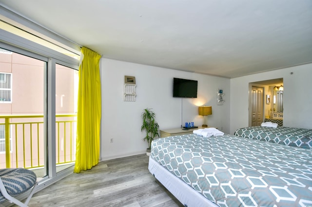 bedroom with access to exterior and light wood-type flooring