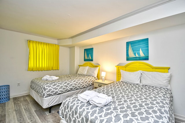 bedroom featuring wood-type flooring and ornamental molding