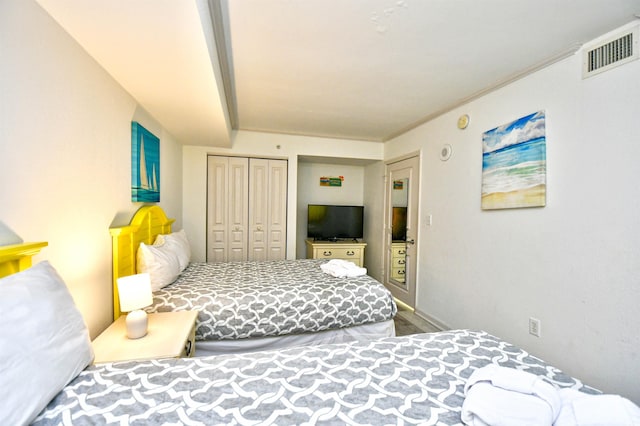 bedroom with crown molding, a closet, and hardwood / wood-style flooring