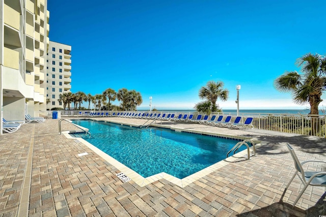 view of pool featuring a patio area and a water view