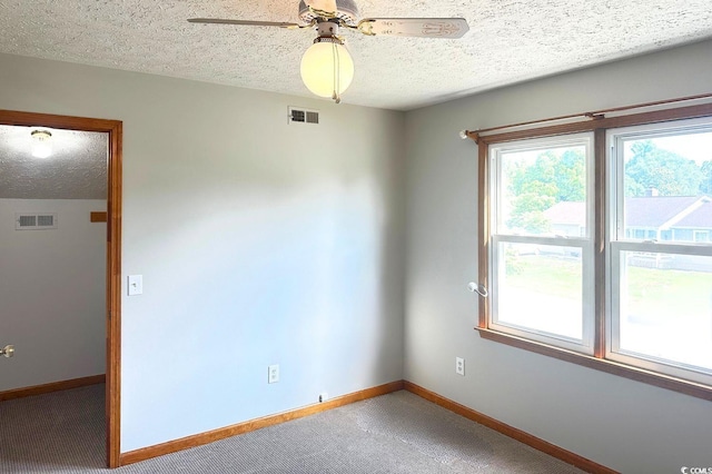 carpeted spare room with a textured ceiling and ceiling fan