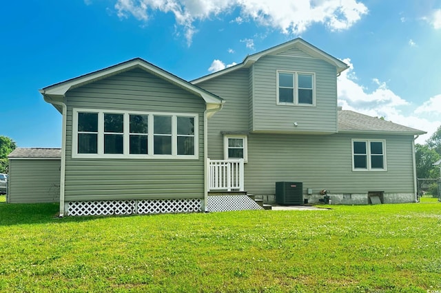 rear view of property featuring a lawn and central AC unit