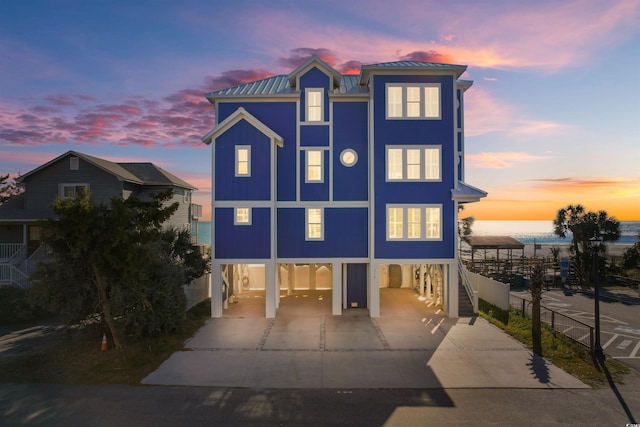 219 S Seaside Dr, Surfside Beach, SC 29575 - raised beach house featuring a carport, concrete driveway, a metal roof, and stairway