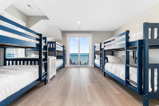219 S Seaside Dr, Surfside Beach, SC 29575 - bedroom with access to exterior, wood finished floors, multiple windows, recessed lighting, and a water view