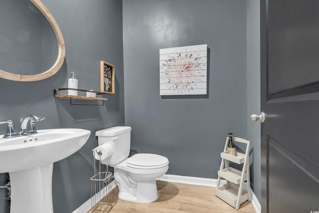 bathroom featuring hardwood / wood-style floors, toilet, and sink