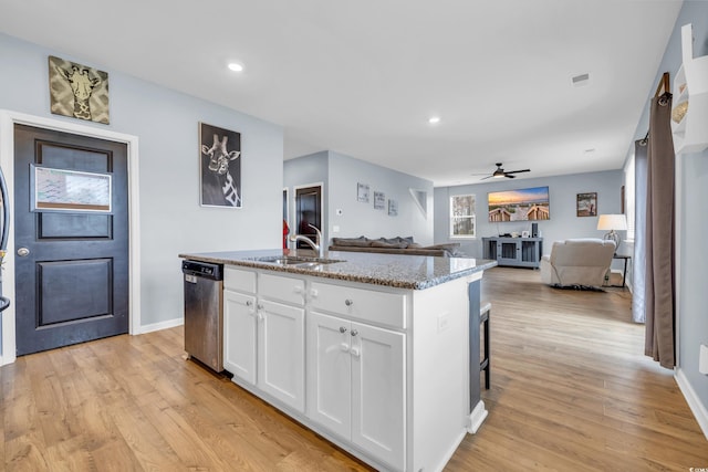 kitchen featuring dishwasher, white cabinets, ceiling fan, light wood-type flooring, and an island with sink