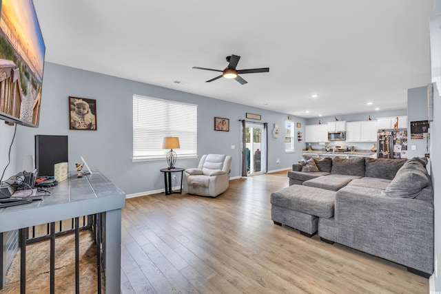 living room featuring ceiling fan and light hardwood / wood-style flooring